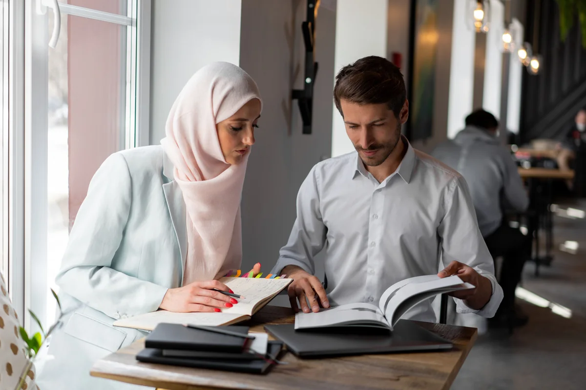 Two people reading through documents together at a table